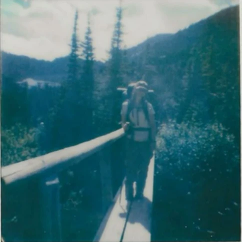 A traveler on a bridge in the mountains